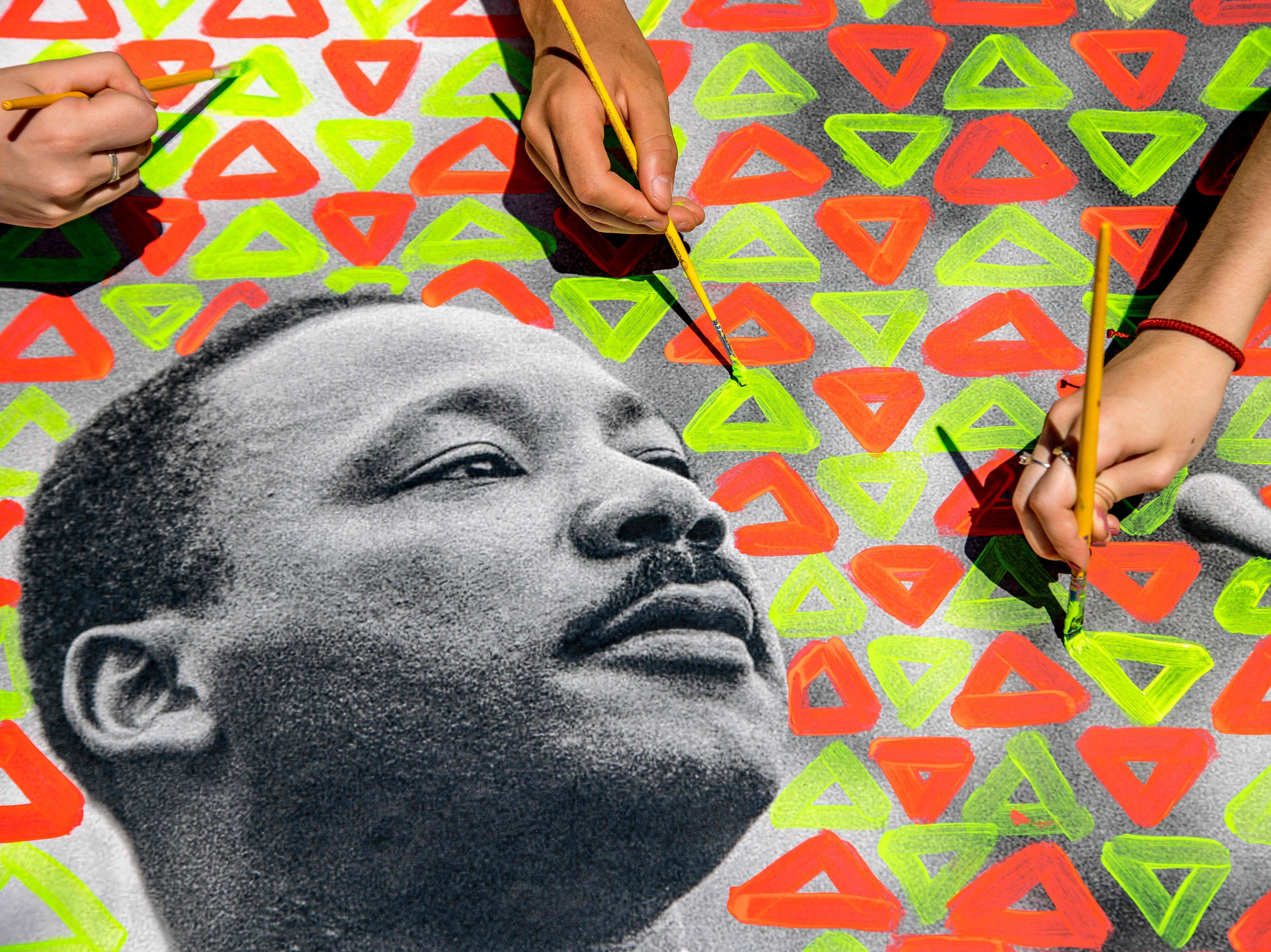 caption: Students from municipal schools in Caxias do Sul, a city with a majority white population in the state of Rio Grande do Sul, Brazil, paint an image of US civil rights leader Martin Luther King Jr., as they participate in a program called "Qualifying Education of Ethnic-Racial Relations."