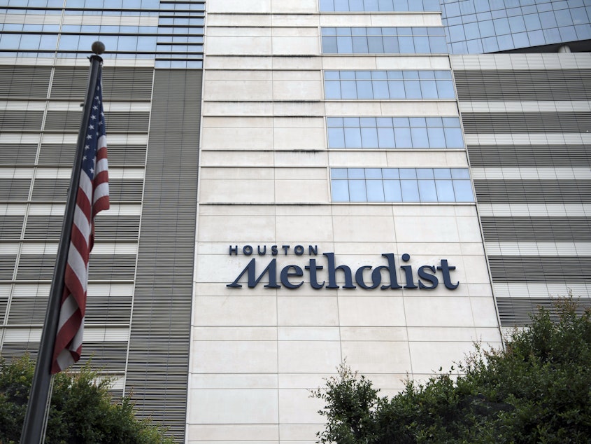 caption: An American flag flies outside the Houston Methodist Hospital at the Texas Medical Center (TMC) campus in Houston, Texas.