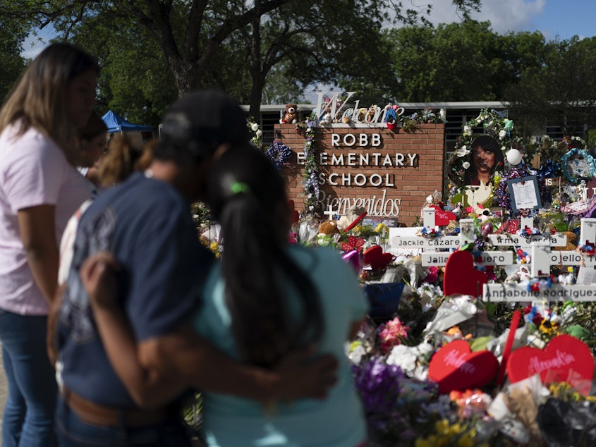 caption: People visit a memorial at Robb Elementary School in Uvalde, Texas, on June 2, 2022, to pay their respects to the victims killed in a school shooting.