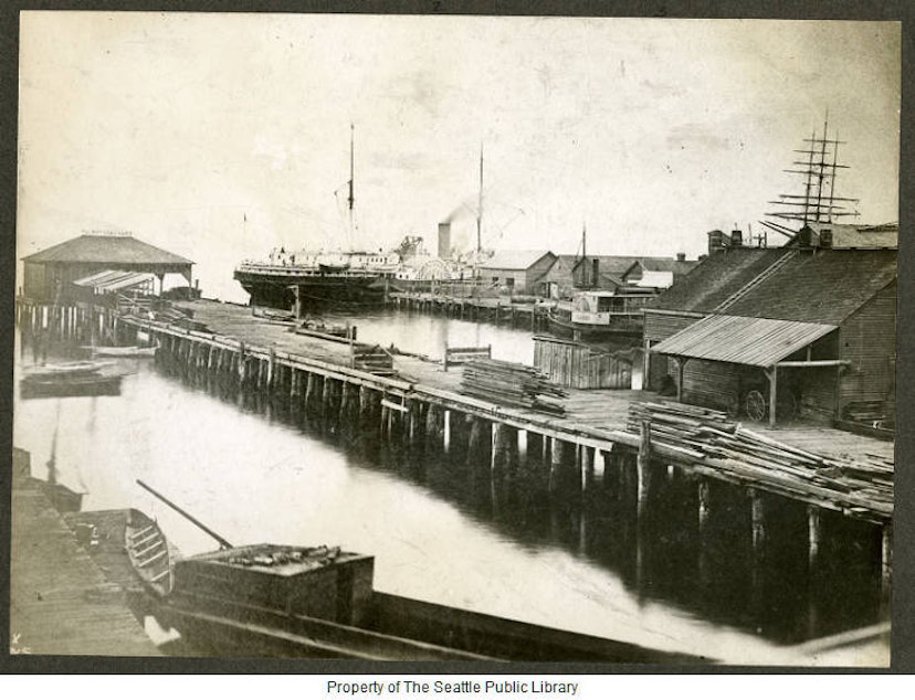 caption: The Seattle waterfront in 1880. This area was known as Yesler Wharf; it would today be one of the piers near the aquarium. 