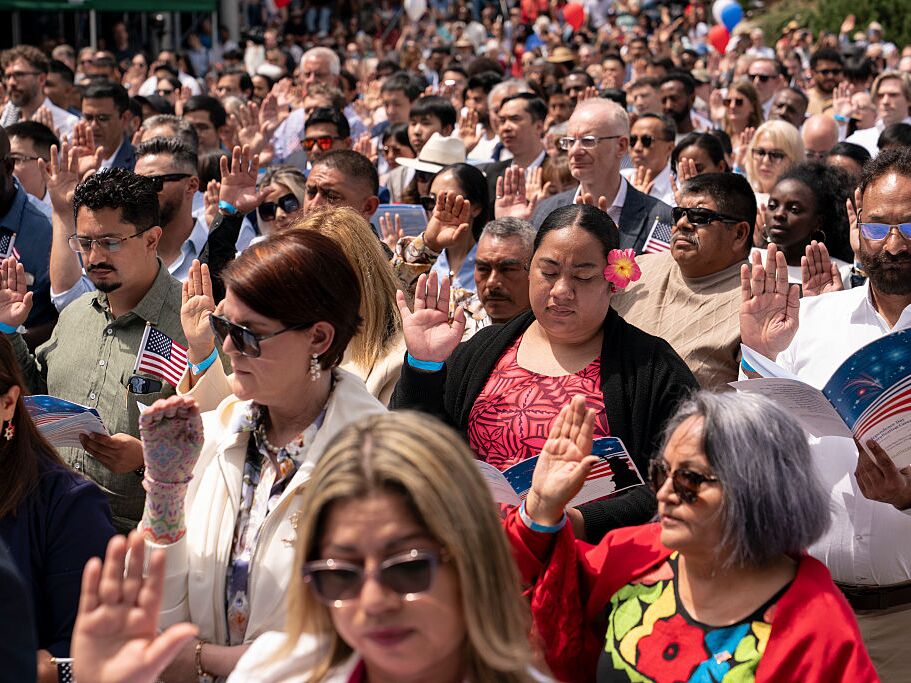 caption: Participants recite the Oath of Allegiance during a naturalization ceremony for new U.S. citizens in Seattle on July 4, 2025. Under the Trump administration, new applicants for naturalization will have to take a more difficult civics test that the government says is intended to ensure that only immigrants who are "fully assimilated" will become new citizens. (Photo by David Ryder/Getty Images)