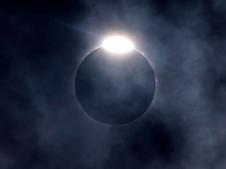 caption: The diamond ring effect as well as Bailey's Beads are seen as the moon eclipses the sun on April 8, 2024, in Fort Worth, Texas.