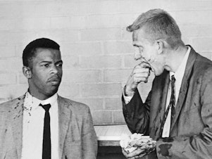 caption: Two blood-splattered Freedom Riders, John Lewis and James Zwerg stand together after being attacked and beaten by pro-segregationists in Montgomery, Alabama.