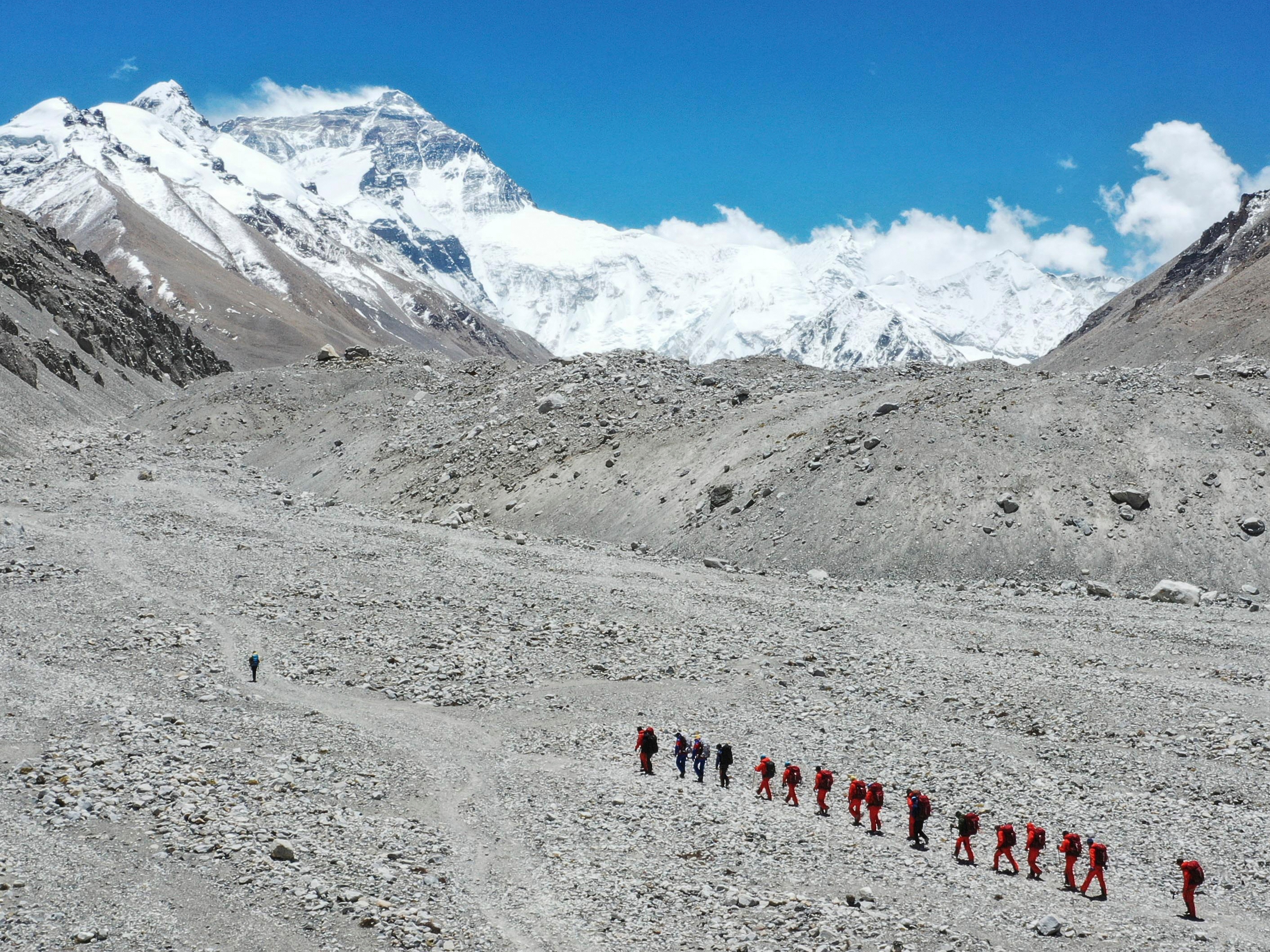 caption: FILE - In this May 16, 2020 aerial photo released by Xinhua News Agency, Chinese surveyors hike toward a higher spot from the base camp on Mount Qomolangma at an altitude of 5,200 meters.