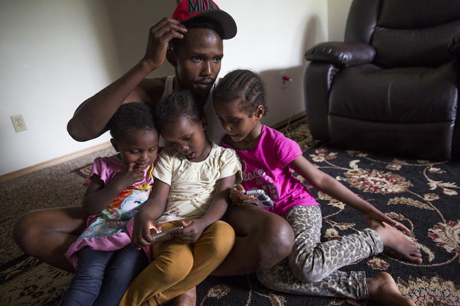 caption: Osman Mohamed, of Somalia, and his three daughters, ages 2, 4 and 5 at their Seattle apartment in 2016.