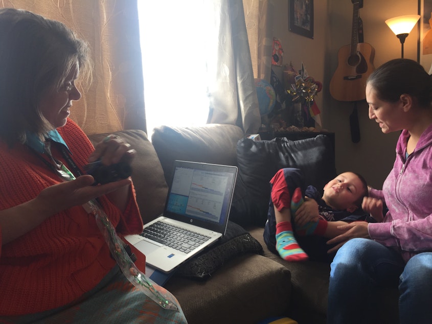caption: GLEA family advocate Camille Churchill visits with four-year-old Moise, and his mother, Angela Madrid