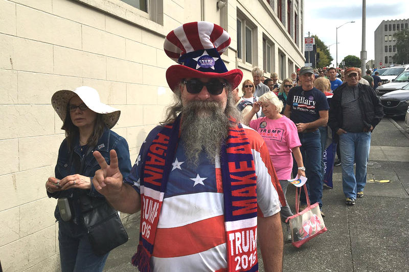 caption: Boeing worker Michael McNeil waits in line Tuesday afternoon to get into Everett's Xfinity Arena to hear Donald Trump speak.