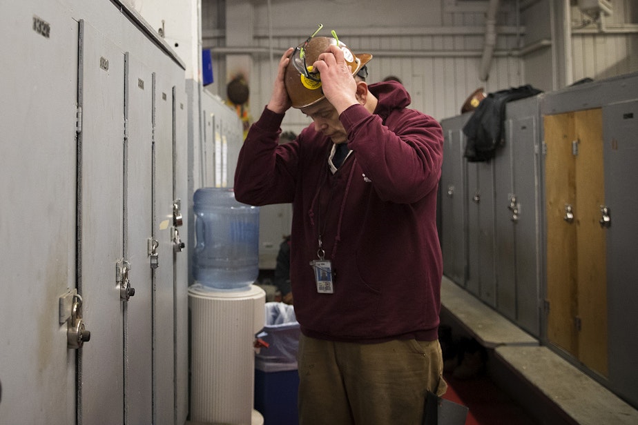 caption: Kevin Boggs gets ready for work in the locker room on Friday, December 14, 2018, at Vigor's ship yard in Seattle. 