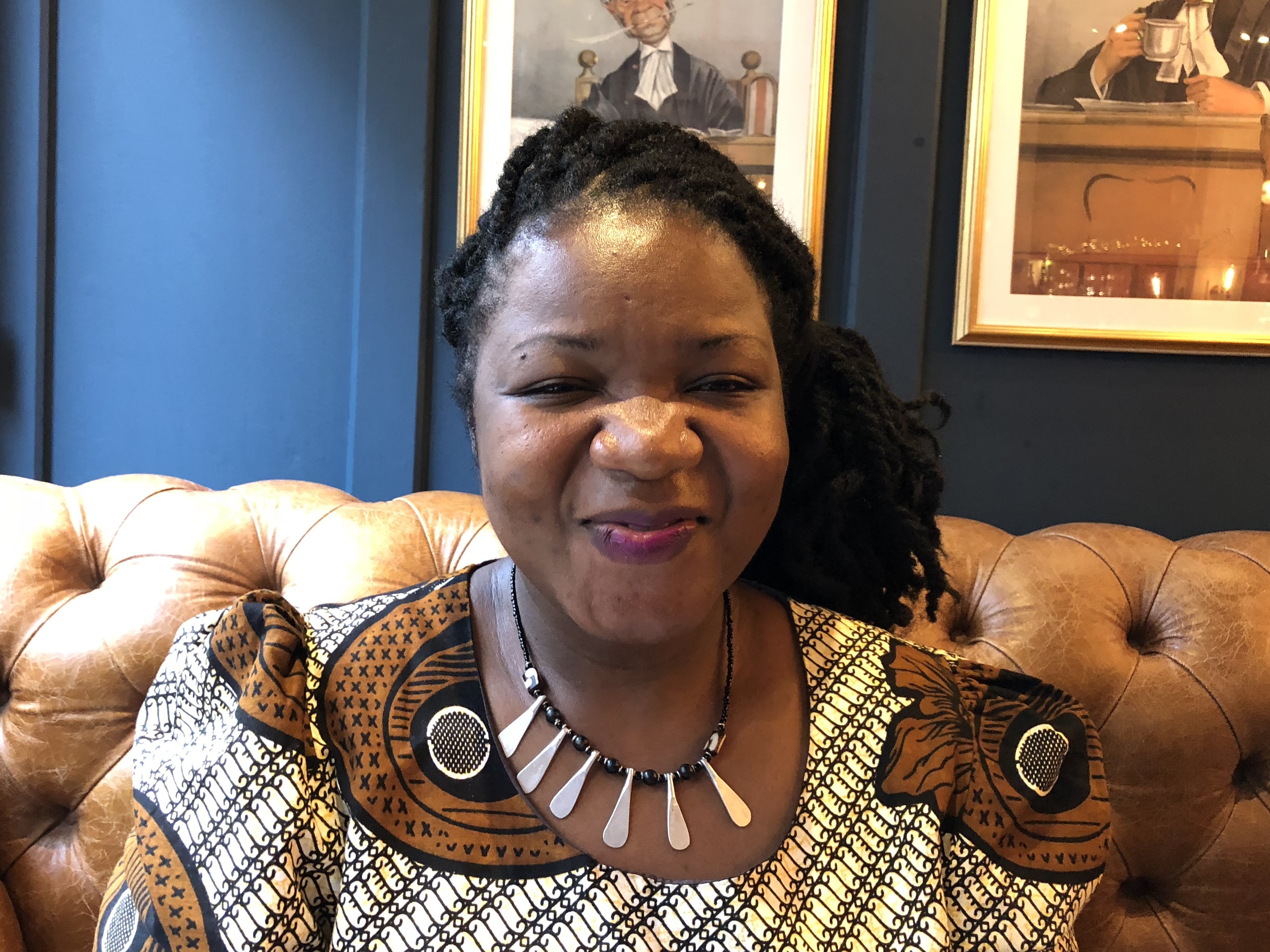 caption: Angeline Murimirwa, executive director of the girls' education group Camfed in Africa, at a pub in Oxford, England, in 2018. In August, Camfed was awarded the $2.5 million 2021 Hilton Humanitarian Prize.