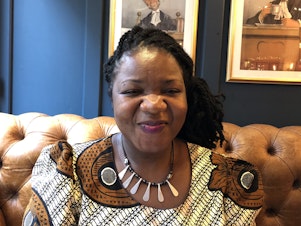 caption: Angeline Murimirwa, executive director of the girls' education group Camfed in Africa, at a pub in Oxford, England, in 2018. In August, Camfed was awarded the $2.5 million 2021 Hilton Humanitarian Prize.