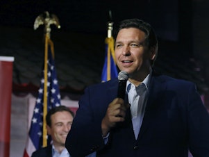 caption: Florida Gov. Ron DeSantis is being sued on behalf of migrants who were flown to Martha's Vineyard last Wednesday without warning.
