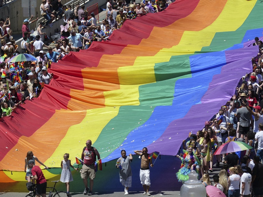 caption: Marchers raise a rainbow flag during the 2018 Pride parade in Salt Lake City. Late Tuesday, state regulators implemented a ban on "conversion therapy" aimed at changing the sexual orientation or gender identity of LGBTQ young people.