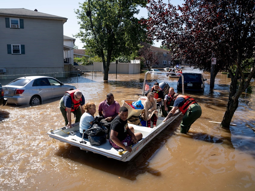 caption: Members of the fire department in Lodi, N.J., perform water rescues of trapped residents following torrential rains from the remnants of Hurricane Ida on Thursday.