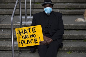 caption: Reverend Wayne Perryman attends the 'We Are Not Silent' rally against anti-Asian hate and violence on Saturday, March 13, 2021, at Hing Hay Park in Seattle. Several days of actions are planned by rally organizers in the Seattle area following recent attacks and violence against Asian American and Pacific Islander communities.
