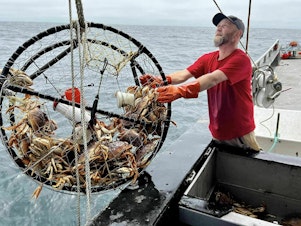 caption: Deckhand Justin Middleton pulls in a crab trap off San Francisco, where new pop-up fishing gear is being piloted.