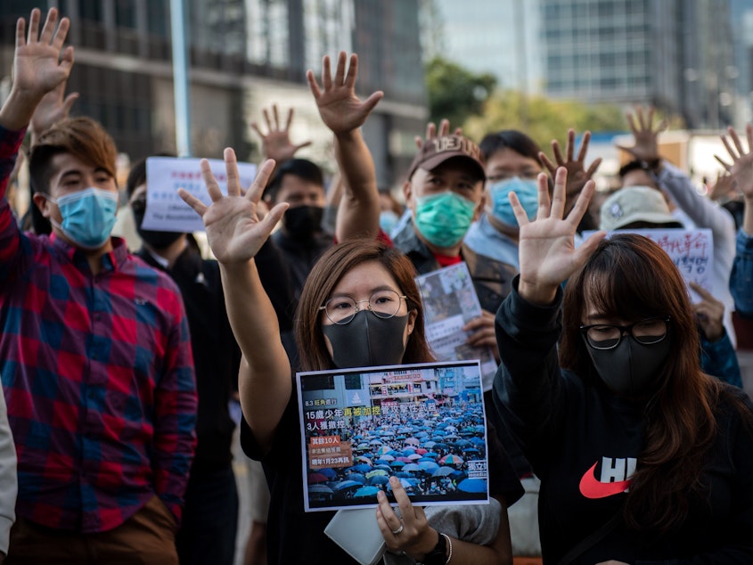 caption: People gather in support of pro-democracy protesters during a lunch break rally in the Kwun Tong area in Hong Kong on Wednesday. Hong Kong has been battered by months of mass rallies and violent clashes between police and protesters who are demanding direct popular elections of the semi-autonomous Chinese territory's government, as well as an investigation into alleged police brutality.