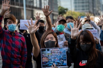 caption: People gather in support of pro-democracy protesters during a lunch break rally in the Kwun Tong area in Hong Kong on Wednesday. Hong Kong has been battered by months of mass rallies and violent clashes between police and protesters who are demanding direct popular elections of the semi-autonomous Chinese territory's government, as well as an investigation into alleged police brutality.