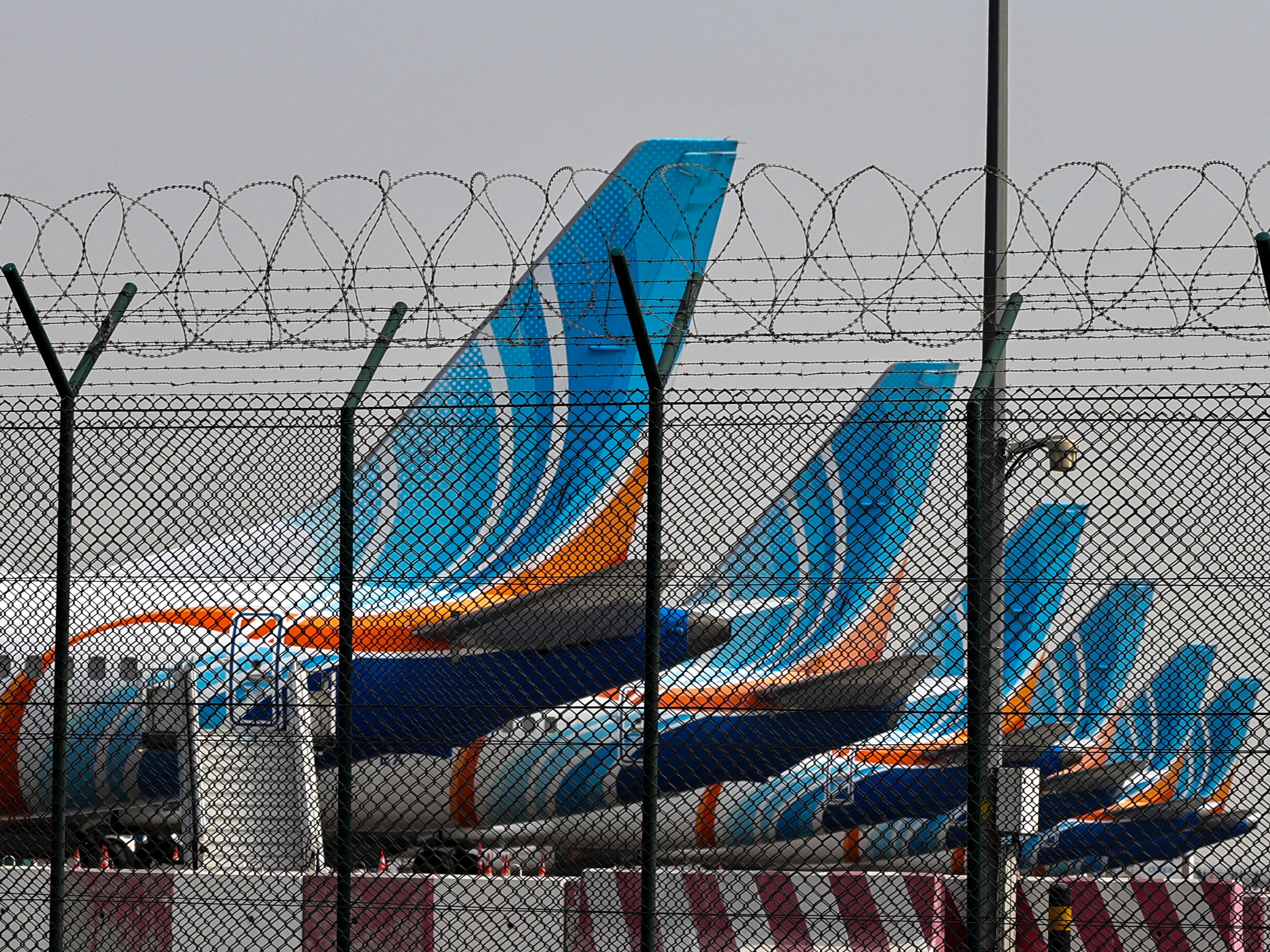 caption: FlyDubai planes are parked at Dubai International Airport on Monday. Many airlines, including several in the Persian Gulf — including those based in Dubai and Abu Dhabi in the United Arab Emirates, Doha in Qatar and others — have curtailed commercial flights for safety reasons following the expanding U.S. and Israeli bombardment in Iran.