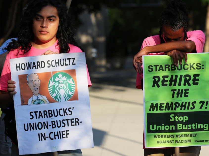 caption: Starbucks says regional staff of the National Labor Relations Board repeatedly crossed the line of neutrality to help union organizers in Kansas. Here, activists protest against Starbucks CEO Howard Schultz in New York City last month.