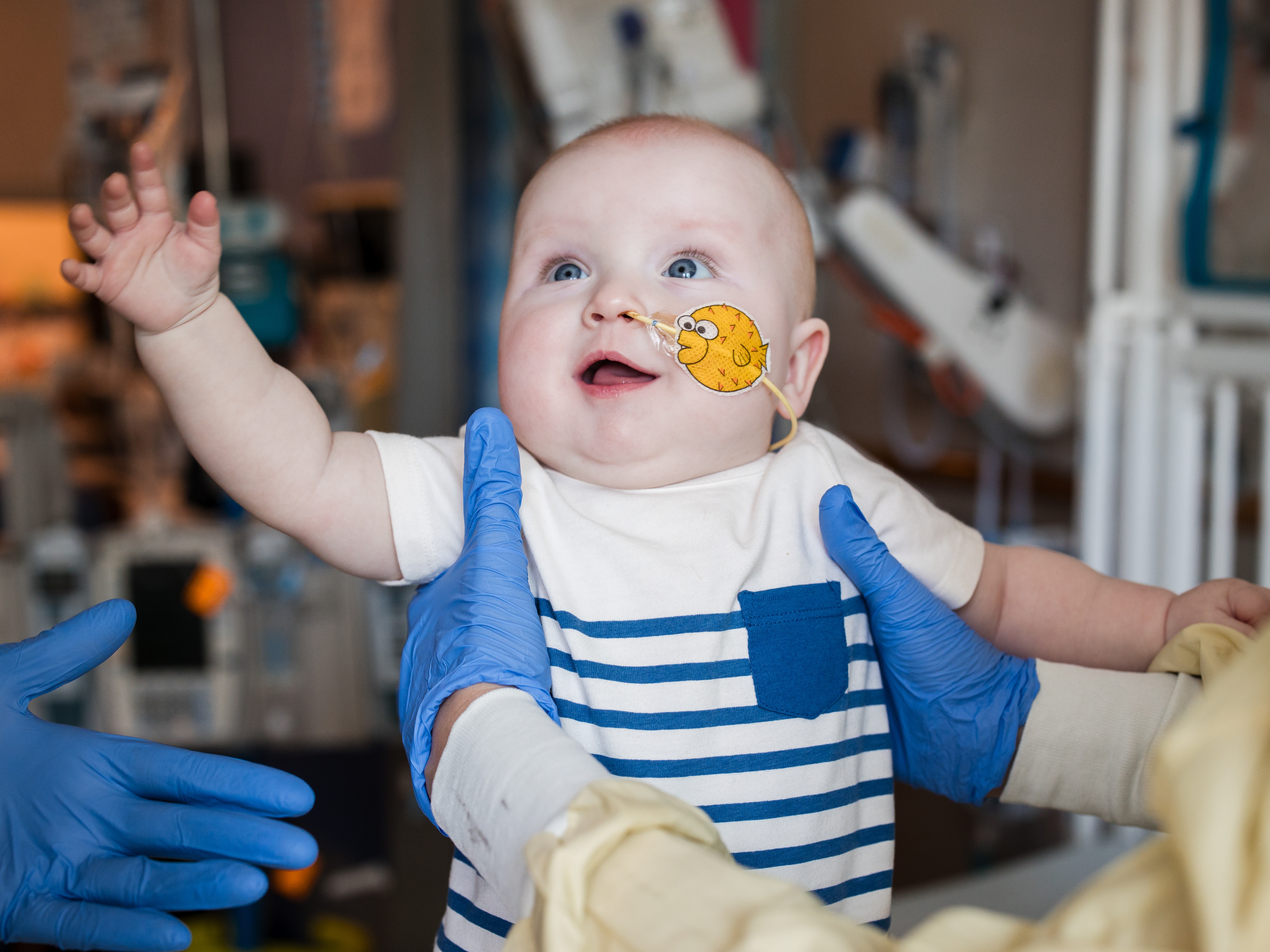 caption: KJ Muldoon, who was born at Children's Hospital of Philadelphia in August, reaches out to doctors after being treated for a rare genetic disorder using CRISPR technology.