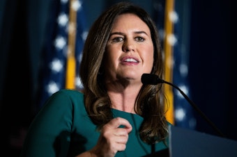 caption: Sarah Huckabee Sanders, former Trump White House press secretary, addresses the America First Policy Institute's America First Agenda Summit at the Marriott Marquis on July 26.