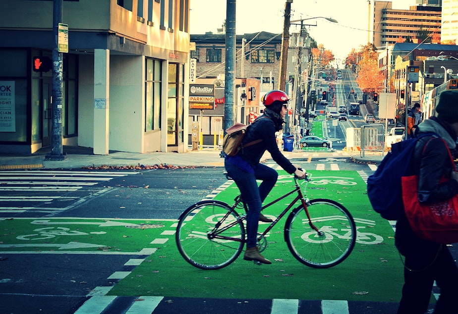 caption: A biker rides in a protected lane on Broadway.