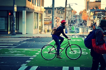 caption: A biker rides in a protected lane on Broadway.