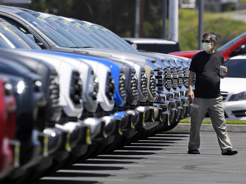 caption: A customer looks at trucks at a Toyota dealership in El Monte, Calif., on Friday. Car sales have been recovering for several weeks, despite the continuing coronavirus outbreak.