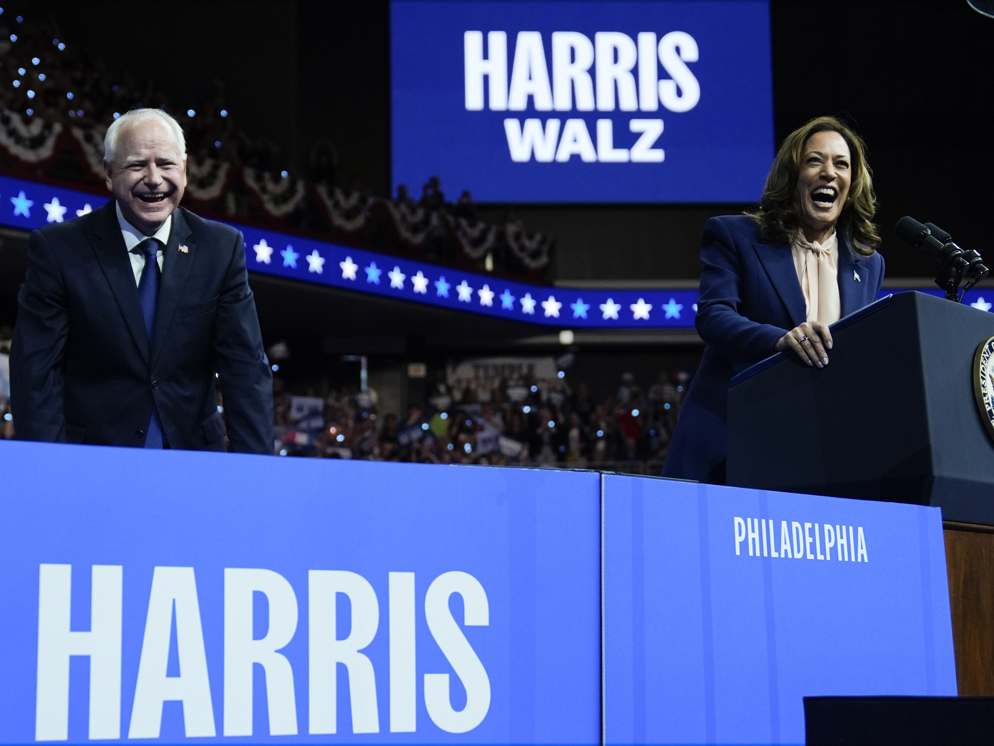 caption: Democratic presidential nominee Vice President Kamala Harris and her running mate Minnesota Gov. Tim Walz speak at a campaign rally in Philadelphia, Tuesday, Aug. 6.