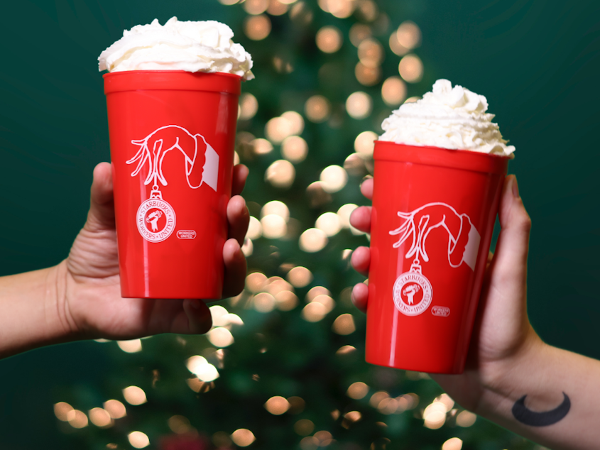 caption: Starbucks Workers United members hope to win over customers who might not be thrilled with the strike by offering an even more exclusive commemorative item: A union-designed red cup with the Starbucks Workers United logo on the front.