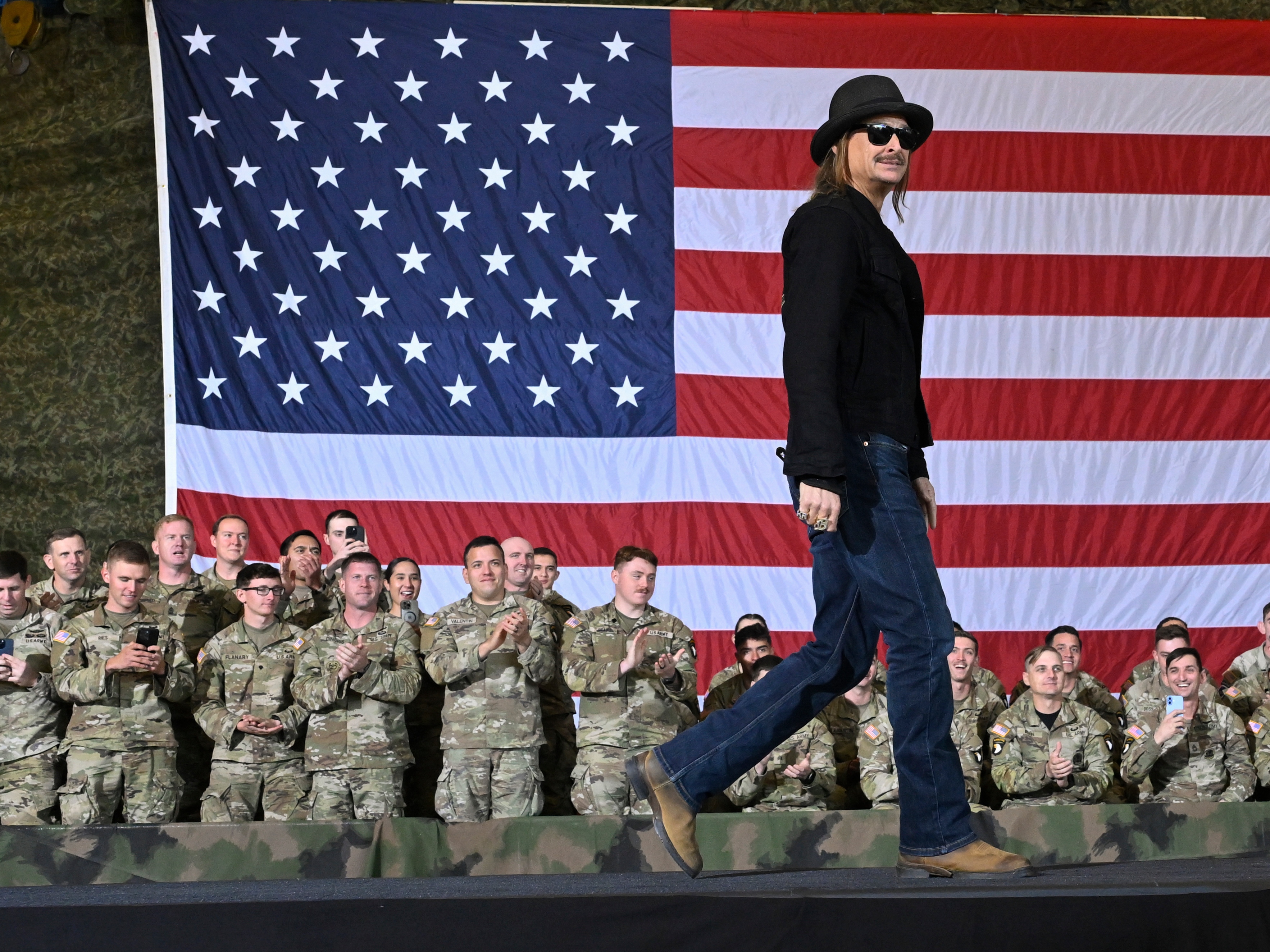 caption: FILE - Kid Rock comes on stage to speak and introduce Vice President JD Vance during a visit to Fort Campbell, Ky., Nov. 26, 2025.