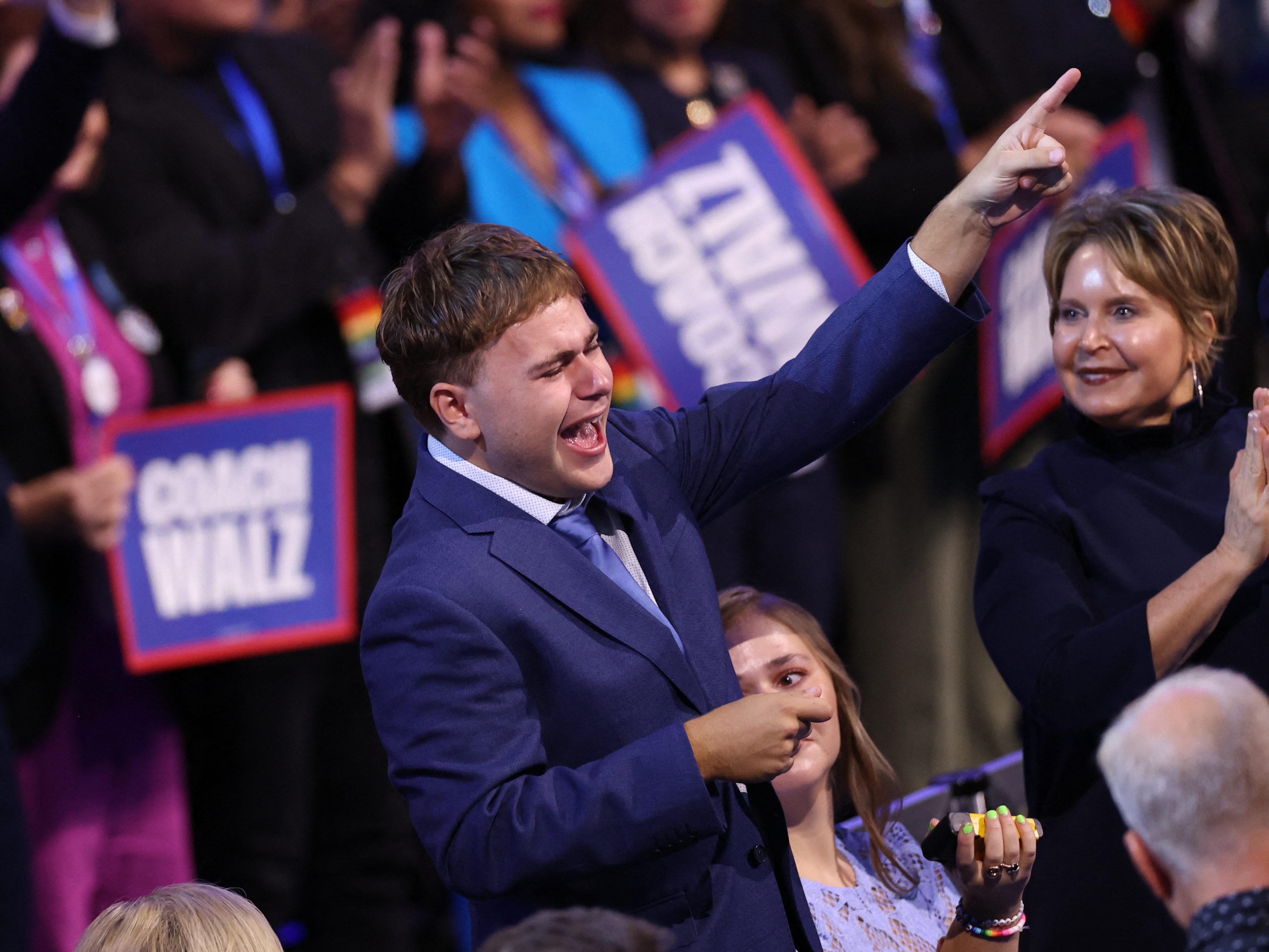 caption: Gus Walz cheers as his father, Minnesota Gov. Tim Walz, gave a shoutout to his family while accepting the Democratic vice presidential nomination on the third day of the Democratic National Convention in Chicago.