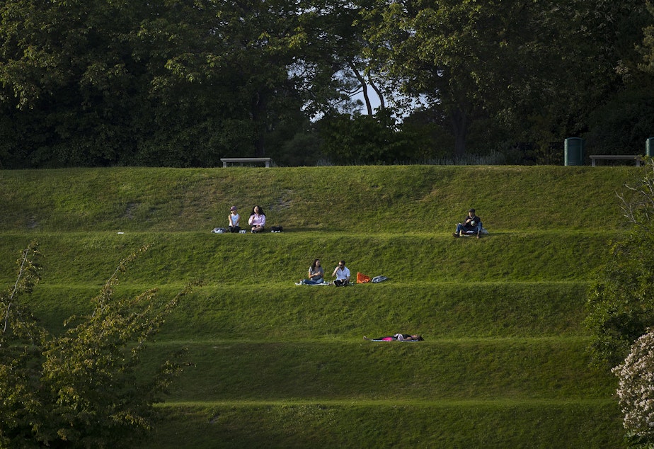 caption: Groups of people sit socially distanced at the Ballard Locks on Friday, June 4, 2021, in Seattle. 