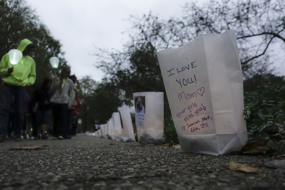 caption: Participants pass bags decorated with messages for the deceased during an Out of the Darkness Walk event organized by the Cincinnati Chapter of the American Foundation for Suicide Prevention in Sawyer Point park, Sunday, Oct. 15, 2017, in Cincinnati. (John Minchillo/AP)