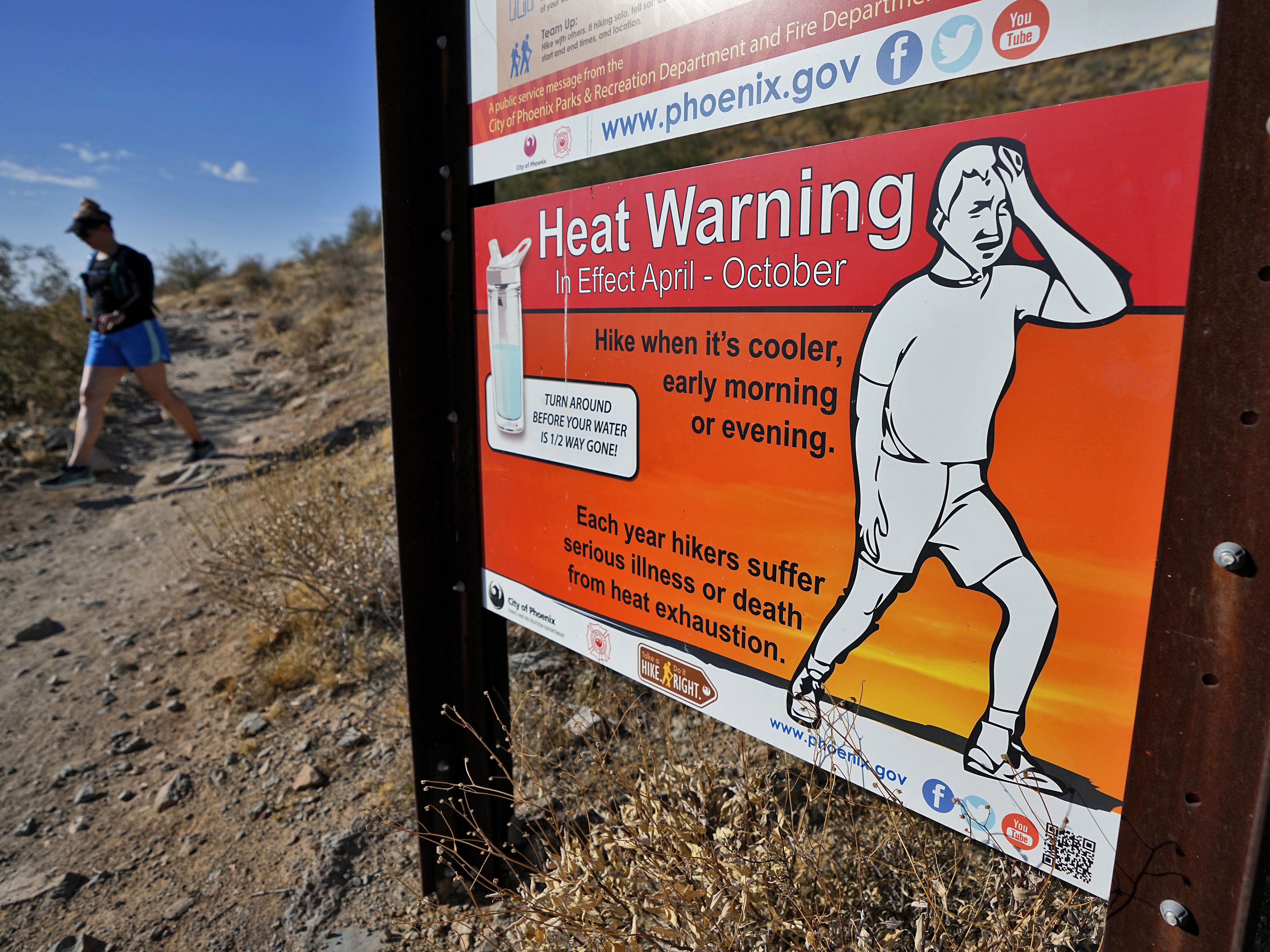 caption: A hiker finishes her hike early to beat high temperatures on July 10, 2023, in Phoenix.