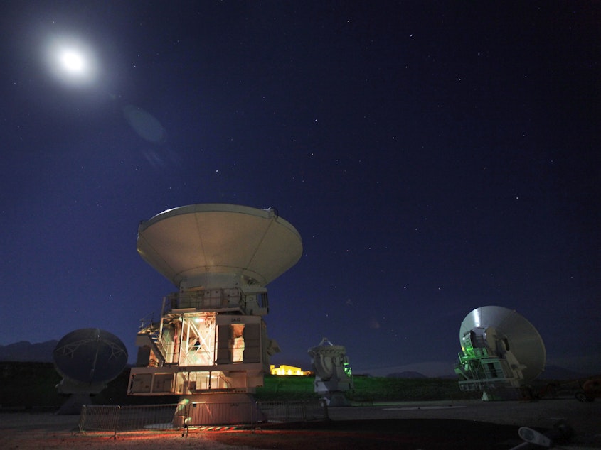 caption: The moon shines over radio antennas at the operations support facility of one of the worlds largest astronomy projects, the Atacama Large Millimeter/submillimeter Array (ALMA), in the Atacama desert in northern Chile in this 2012 photo.