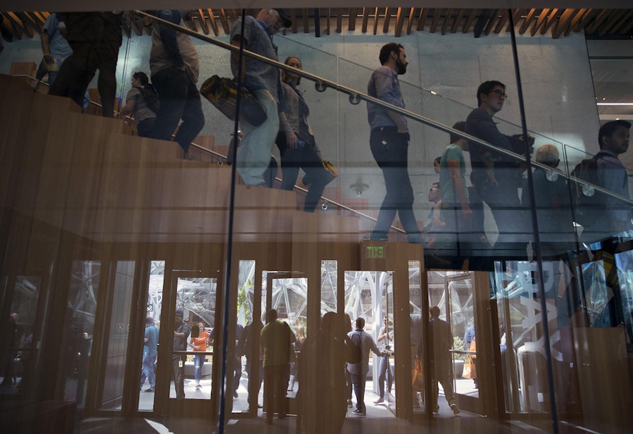 caption: Employees walking in Amazon's Seattle headquarters.