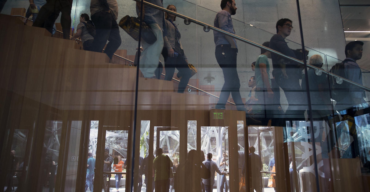 caption: Employees walking in Amazon's Seattle headquarters.