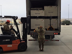 caption: Washington National Guard Members unloading medical supplies
