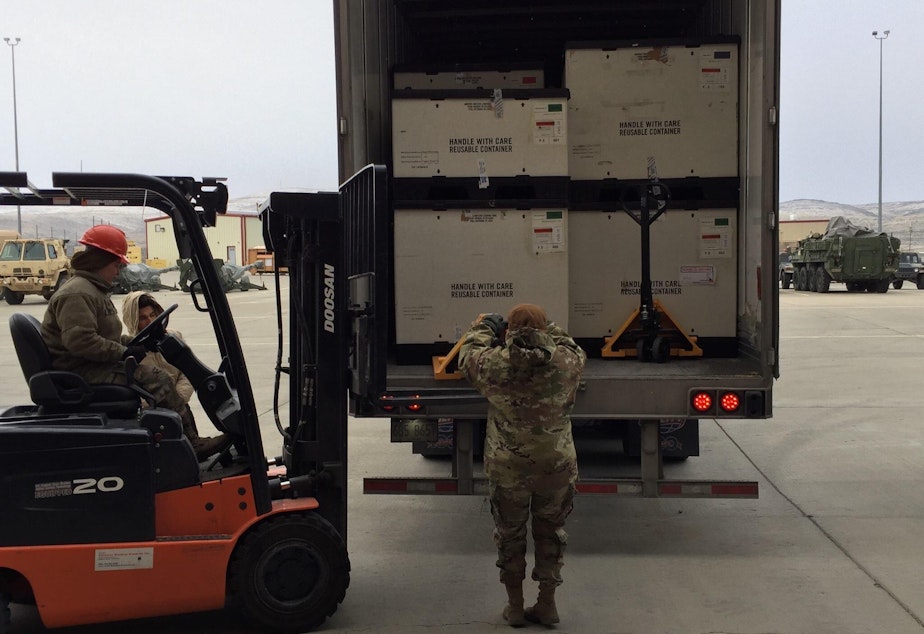 caption: Washington National Guard Members unloading medical supplies