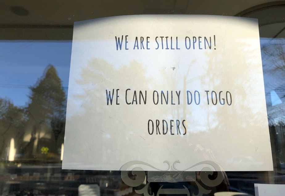 caption: A Seattle cafe notes that while the business is still open, it can only allow to-go orders.