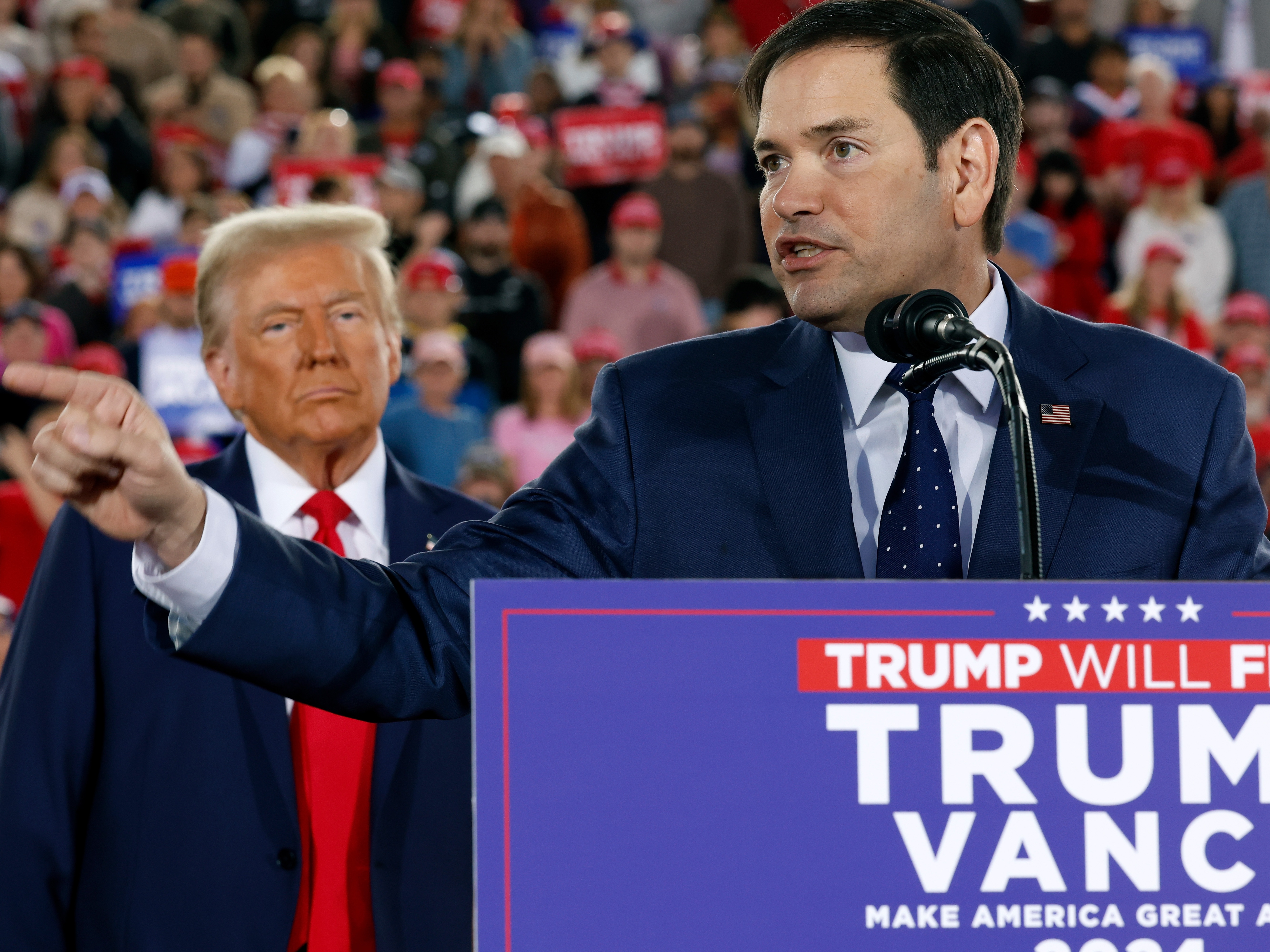 caption: Former President Donald Trump watches as U.S. Sen. Marco Rubio, R-Fla., speaks during a campaign rally on Nov. 4 in Raleigh, N.C.