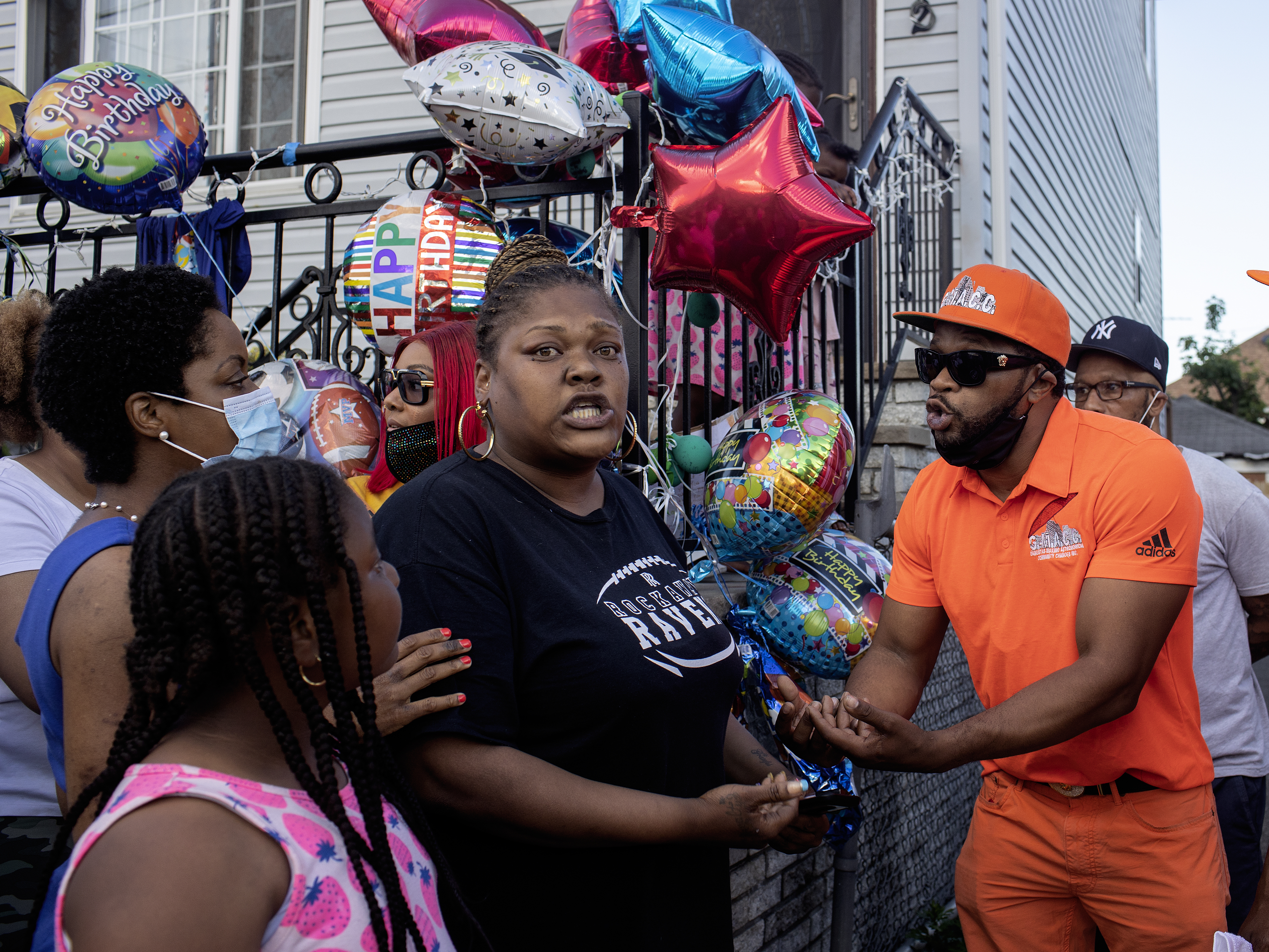 caption: Shanduke McPhatter, a non-violence activist, talks to a woman who recently lost a relative to gun violence. The peace vigil took place on the block where 10-year-old Justin Wallace was shot to death.