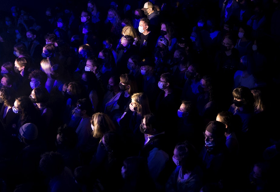 caption: A crowd of masked people listen as Madeline The Person performs on Friday, November 12, 2021, at Neumos along East Pike Street in Seattle. 