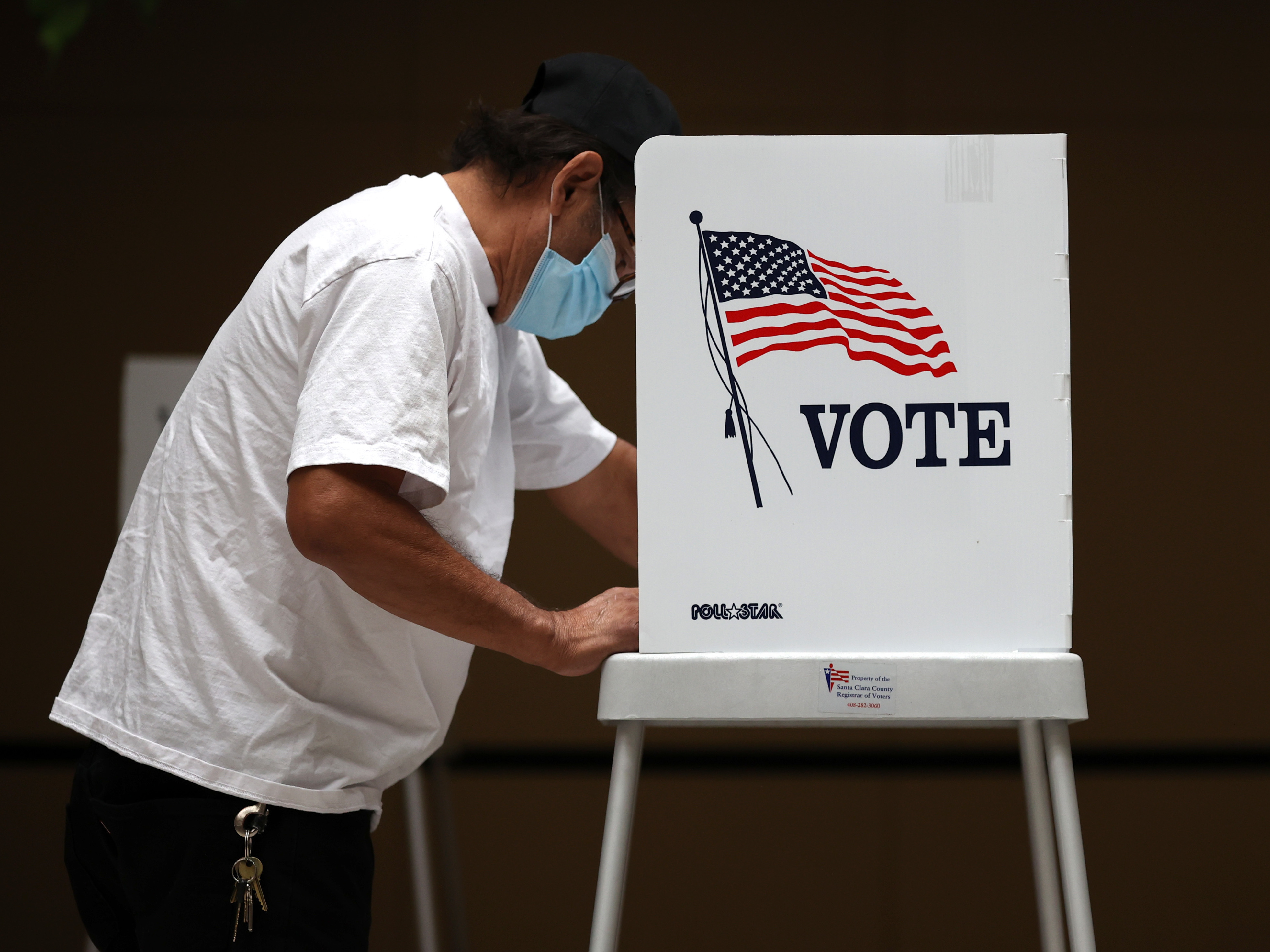 caption: A voter fills out his ballot during early voting at the Santa Clara County Registrar of Voters office last week in San Jose, Calif.