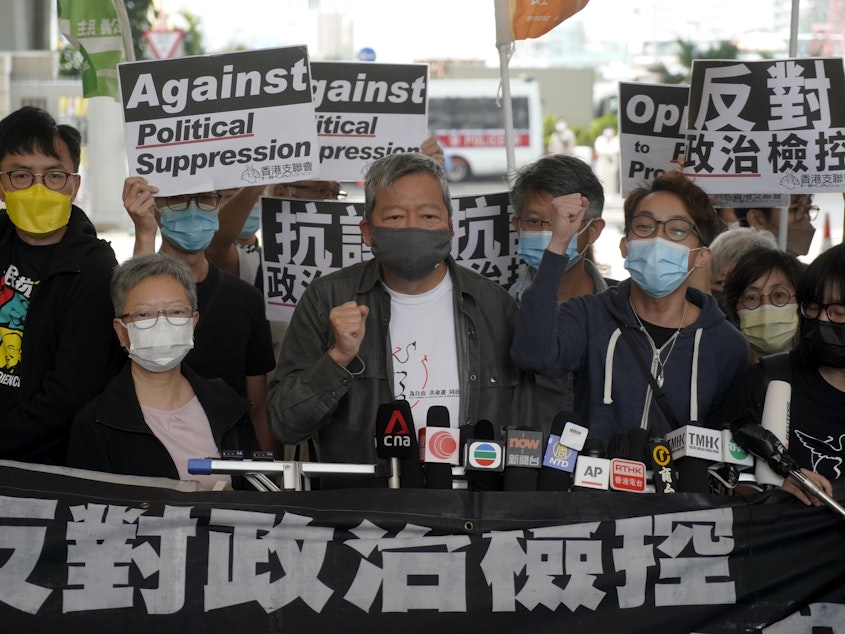 caption: Pro-democracy activist Lee Cheuk-yan, center, arrives at a court in Hong Kong Friday.  Seven of Hong Kong's leading pro-democracy advocates, including Lee, and pro-democracy media tycoon Jimmy Lai, were sentenced Friday for organizing a march during the 2019 anti-government protests.