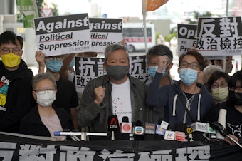 caption: Pro-democracy activist Lee Cheuk-yan, center, arrives at a court in Hong Kong Friday.  Seven of Hong Kong's leading pro-democracy advocates, including Lee, and pro-democracy media tycoon Jimmy Lai, were sentenced Friday for organizing a march during the 2019 anti-government protests.