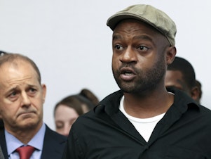 caption: Jeffery Christian, right, speaks at a press conference in Chicago, on May 7. Christian and dozens of others claim they were sexually abused as children while incarcerated at Illinois juvenile detention centers, as part of a lawsuit recounting decades of allegations of systemic child abuse.