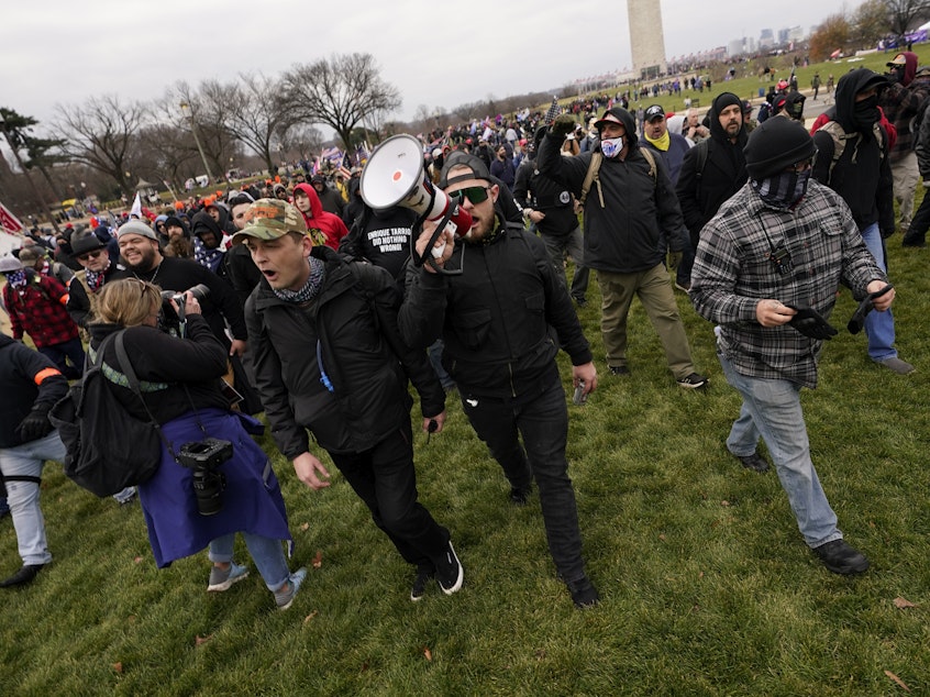 caption: Ethan Nordean, with backward baseball hat and bullhorn, leads members of the far-right group Proud Boys in marching before the riot at the U.S. Capitol on Jan. 6.