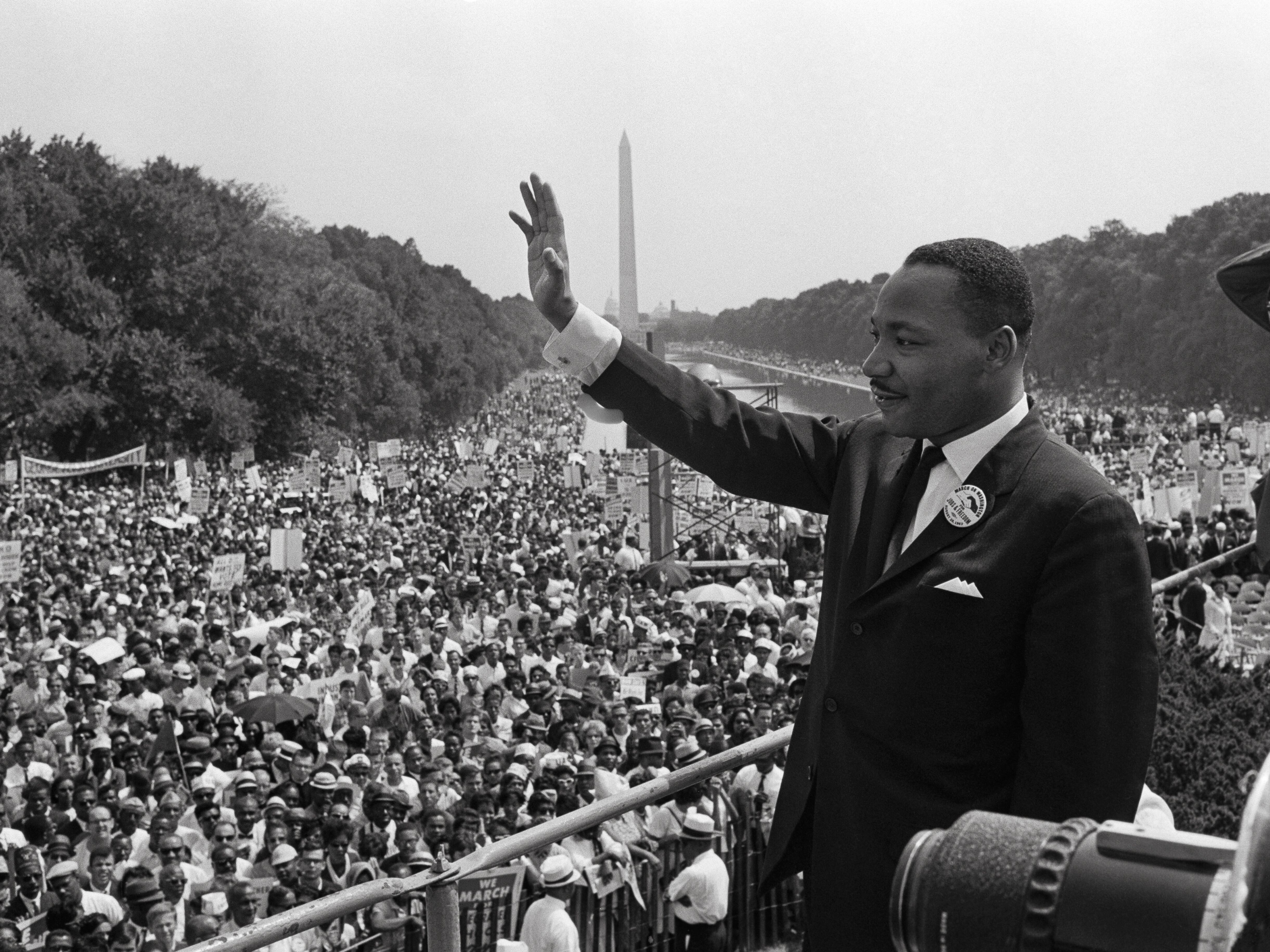 caption: Martin Luther King waves to supporters on August 28, 1963 on the Mall in Washington, D.C., during the March on Washington for Jobs and freedom, where King delivered his famous "I Have a Dream" speech. Many musicians, including Marian Anderson, Mahalia Jackson, Bob Dylan, Joan Baez, Odetta and The Freedom Singers were also at the march.